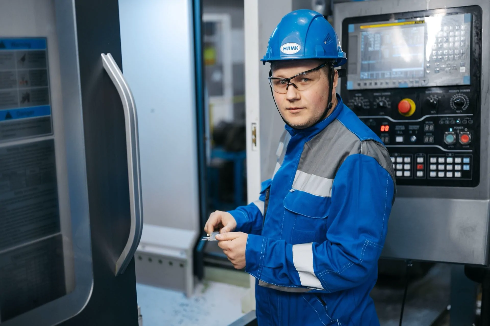 Operator przy panelu sterowania obrabiarki CNC